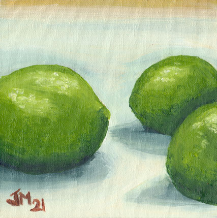 Three green limes arranged on a neutral background